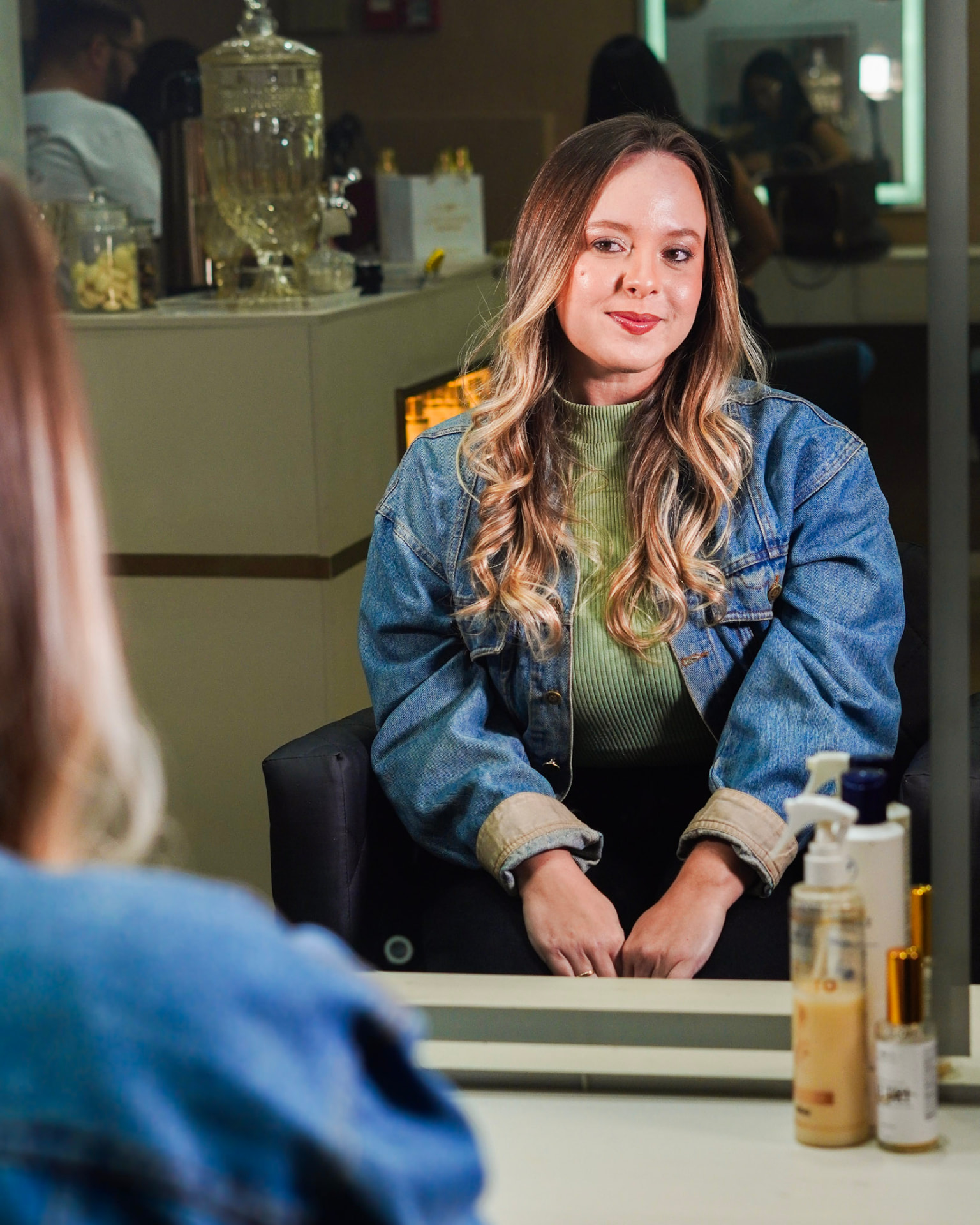 Cliente no espelho após finalização do cabelo