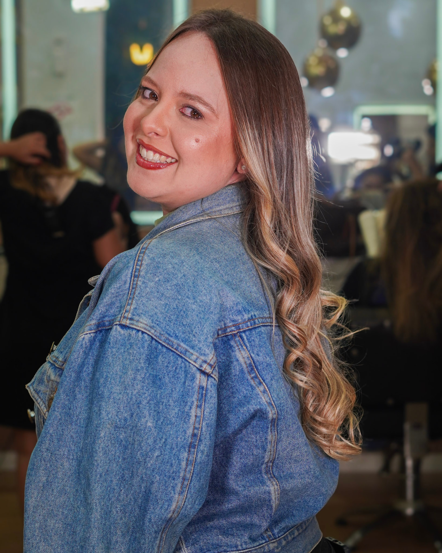 Cliente sorrindo com loiro iluminado e ondas suaves